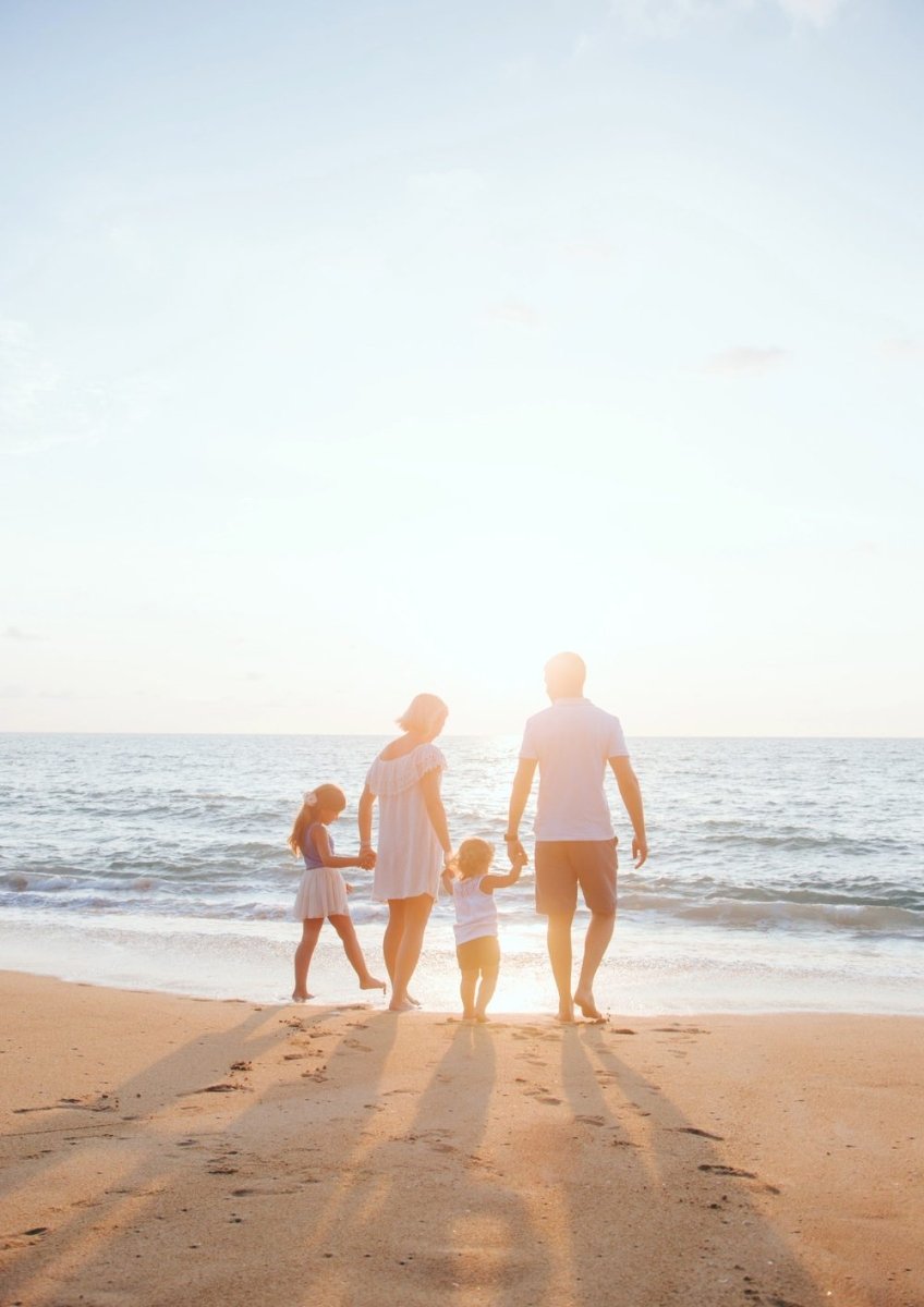 Framed print of a family on the beach at sunset, hanging above a sofa